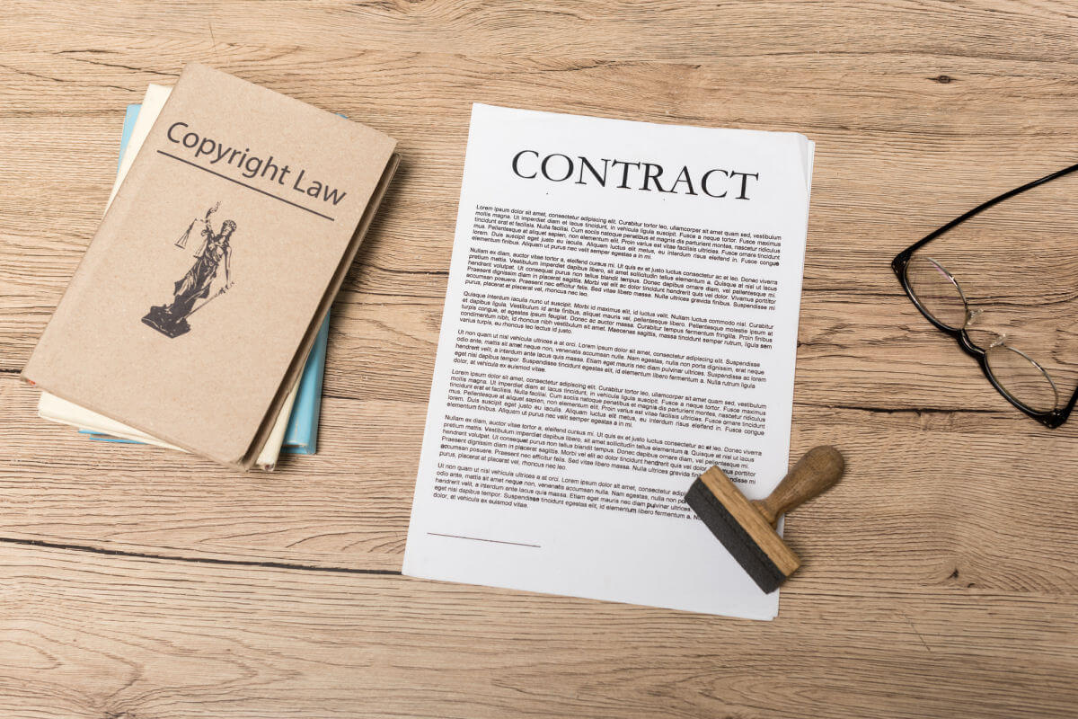 Copyright law books and a contract on a wooden desk
